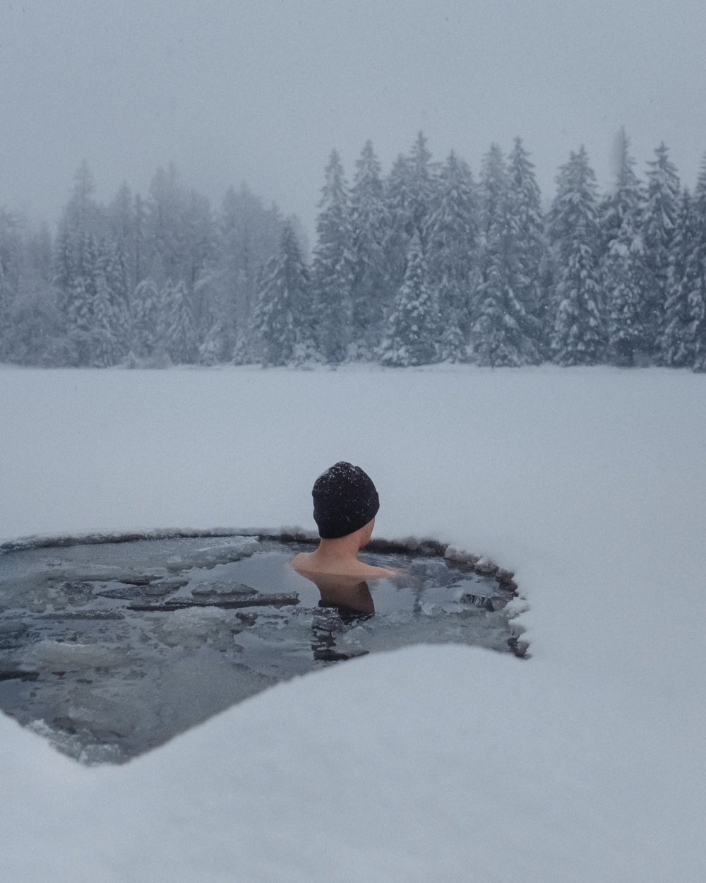 Eisbader im Eisloch bei Schneetreiben