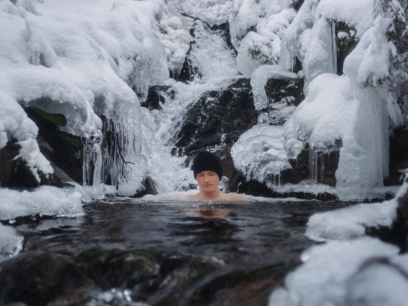 Bathing beneath a frozen waterfall